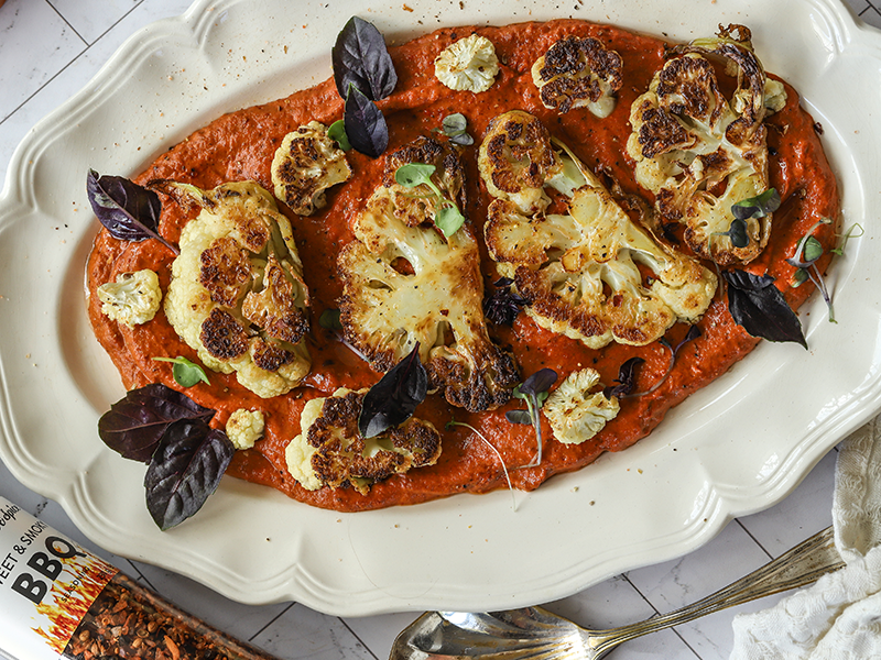Cauliflower steaks on creamy red pepper dip